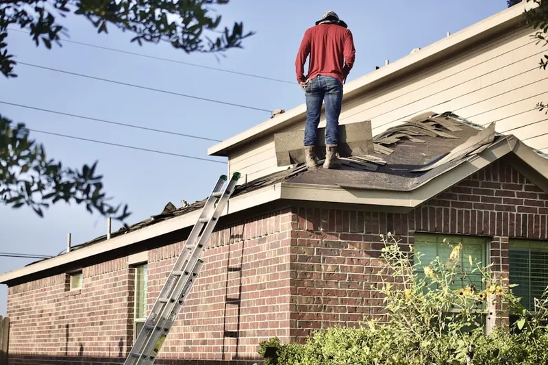 Professional roofer working on a residential roof in Le Grow